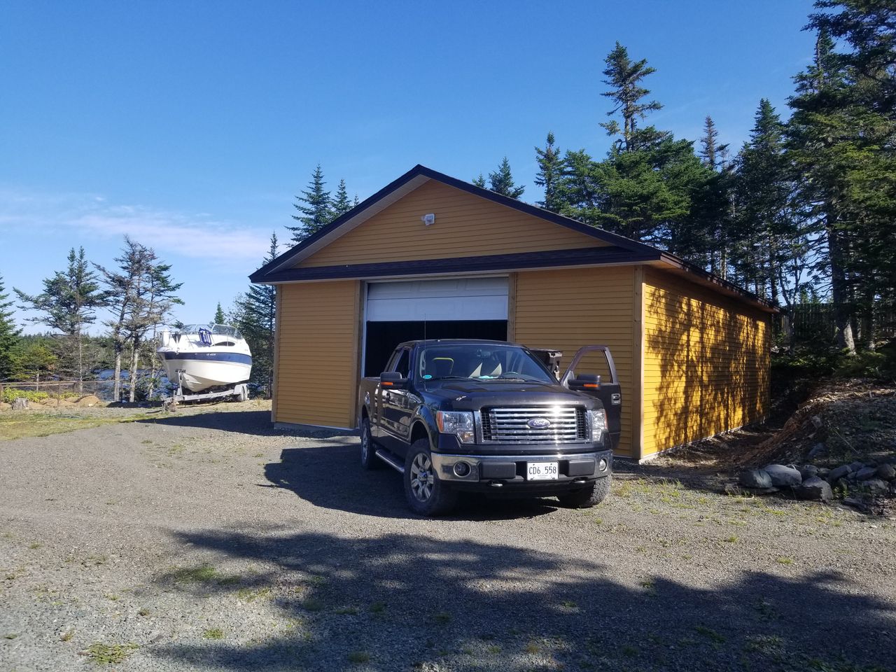 The Art of Drawing Readers In: Your attractive post title goes here A parked truck in front of a yellow garage with a boat nearby in a rural setting.