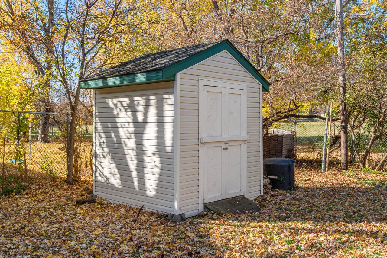 About A quaint backyard shed surrounded by autumn foliage, ideal for storage solutions.
